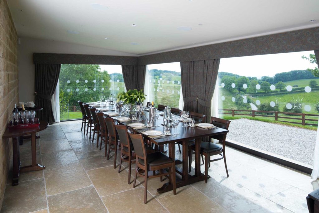 A large dining room with discreet technologies, at a luxurious shooting lodge.