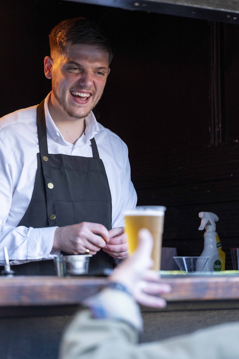 A member of the bar team pouring a drink at the Summer Soiree